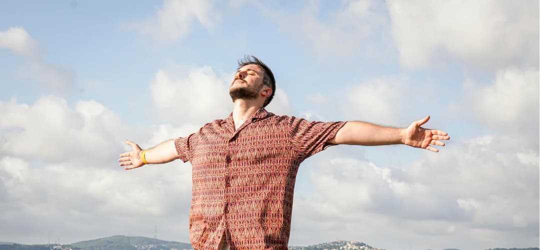 Hombre respirando al aire libre con los brazos abiertos